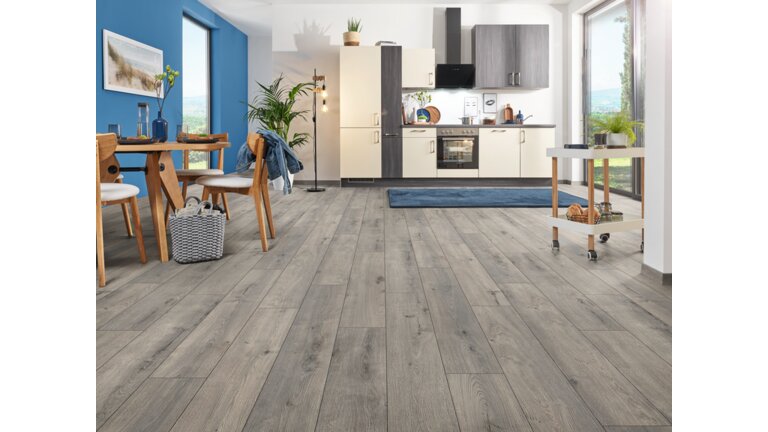 Wohnraum mit grauem Laminatboden in Eichenoptik.